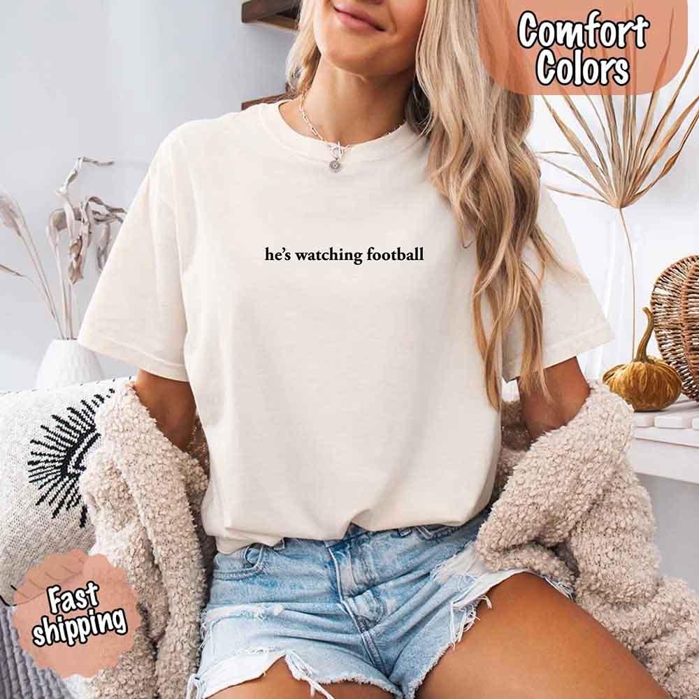 He’s Watching Football Tee - Comfort Colors Funny Shirt for Her